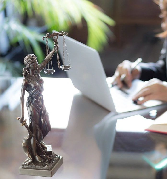 A statue of lady justice is on the table.