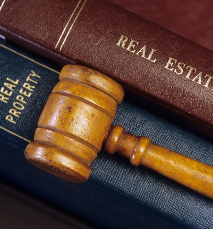 A wooden gavel sitting on top of two books.