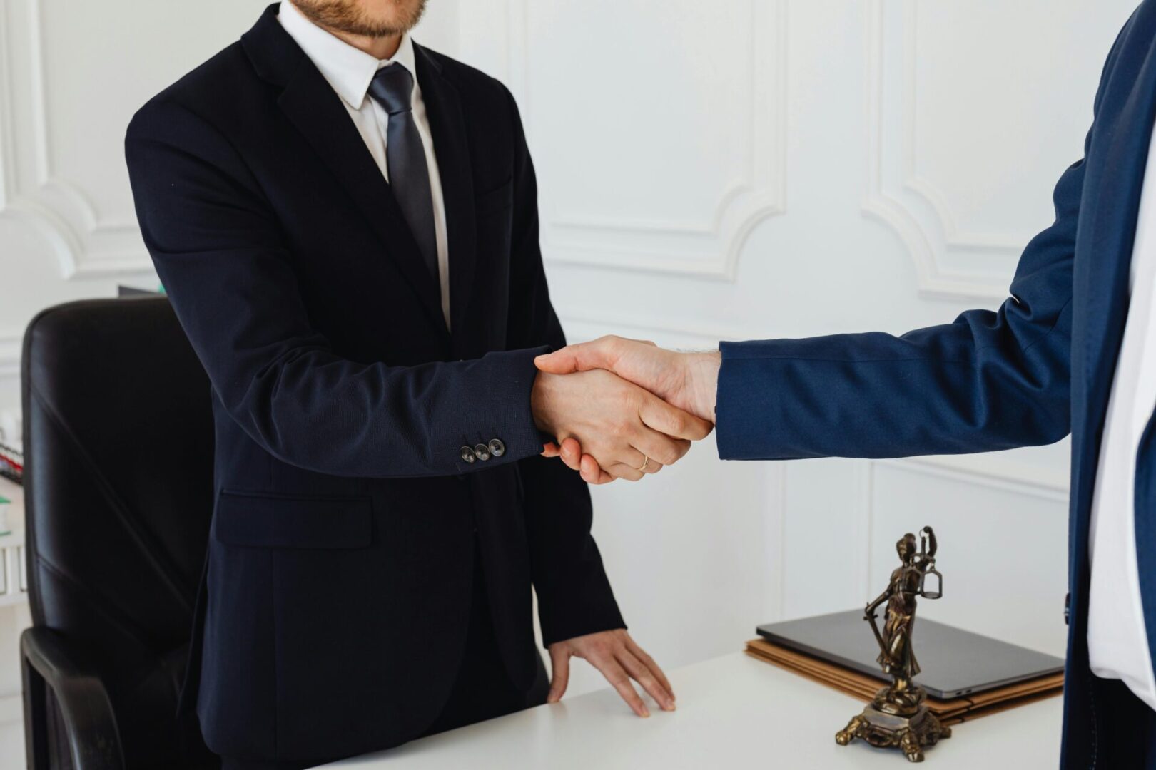 Two people shaking hands over a table